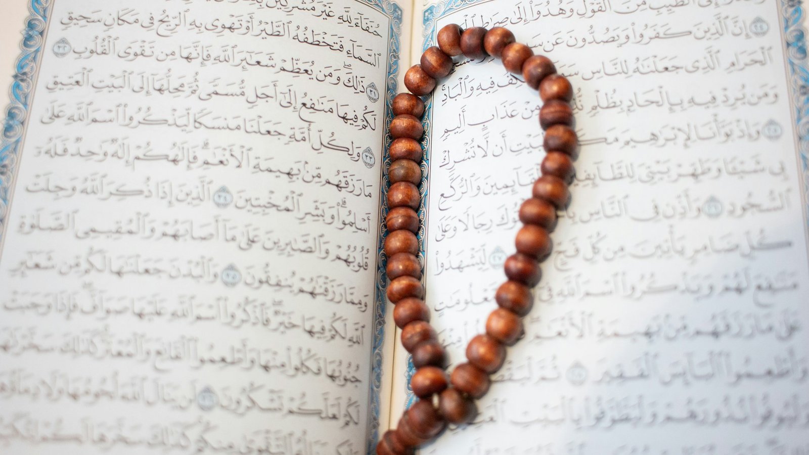 Open Quran with prayer beads for tajweed practice